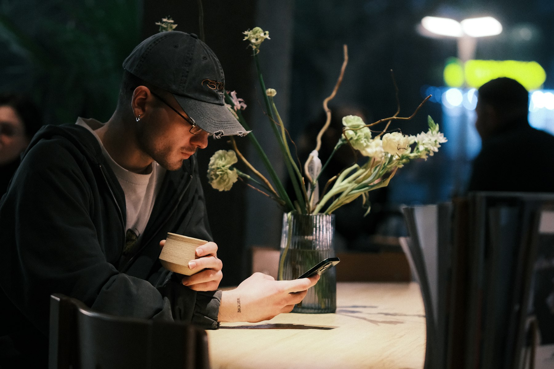 Mann im Café schaut aufs Handy